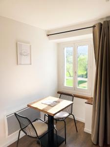 a table and chairs in a room with a window at STUDIOS Neufs - COEUR de Barcelonnette - Parking privé in Barcelonnette
