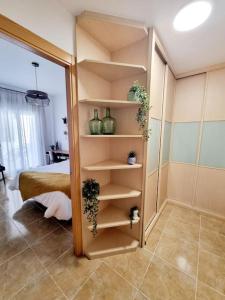 Cette chambre comprend un lit et une étagère avec des vases. dans l'établissement Cal Marc - Piso con piscina y terraza, à Ulldecona