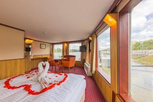 Cette chambre comprend un lit et une table avec vue. dans l'établissement Fortuna Boat Hotel Budapest, à Budapest