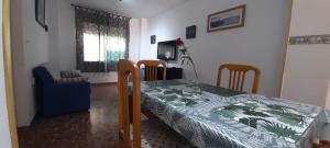 ein Esszimmer mit einem Tisch, einem Tisch und Stühlen in der Unterkunft APARTAMENTO GRETA in Torrenueva