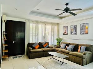 a living room with a couch and a ceiling fan at Country club townhouse in Bang Tao Beach