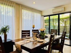 een eetkamer met een houten tafel met stoelen en een tafel bij Country club townhouse in Bang Tao Beach