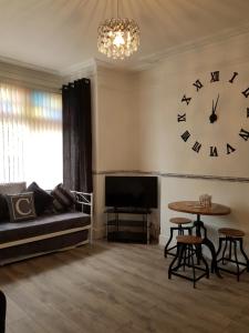 uma sala de estar com um grande relógio na parede em The Cedars Hotel em Lincolnshire