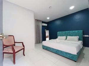 um quarto com uma cama e uma cadeira em RVH Kuala Terengganu em Kuala Terengganu