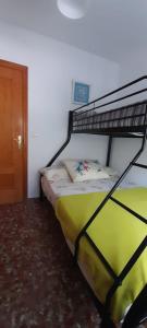 ein Schlafzimmer mit einem Etagenbett in einem Zimmer in der Unterkunft APARTAMENTO GRETA in Torrenueva