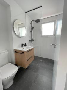 a bathroom with a toilet and a sink and a mirror at Apartamento Colina B 19. in Córdoba