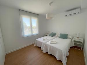um quarto branco com uma cama e uma janela em Apartamento Colina B 19. em Córdoba