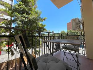 un balcón con mesa, sillas y un árbol en Apartamento Colina B 19., en Córdoba