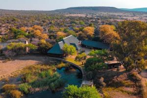 an aerial view of a house with a bridge over a river at Mela Luxury Game Lodge in Pretoria