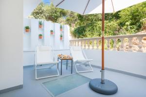 a patio with a table and chairs and an umbrella at Boutique Hotel Oriola in Cala de Sant Vicenc