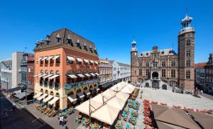 uma rua da cidade com um mercado em frente a um edifício em Stadsherberg Ald Weishoès em Venlo