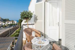 a balcony with a table and chairs and a window at Boutique Hotel Oriola in Cala de Sant Vicenc