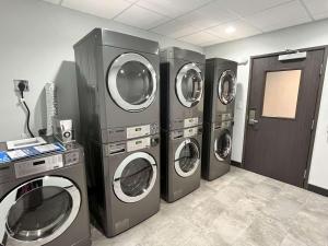 four washers and dryers in a laundry room at Motel 6 Fort Worth TX Lake Worth in Fort Worth