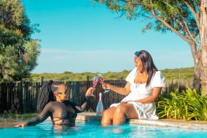 una mujer y un niño jugando en una piscina en Mela Luxury Game Lodge en Pretoria