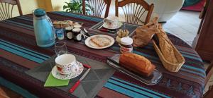 a table with a breakfast of coffee and bread at Chambre d'hôtes in Le Mans
