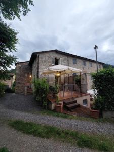 a house with a deck with an umbrella at Casina Laura in Capannori