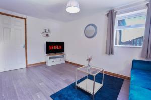 a living room with a blue couch and a tv at Beautiful 2 Bedroom,freeParking L Buzzard in Leighton Buzzard