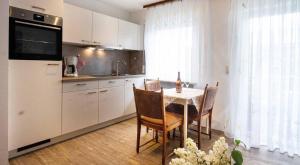 a kitchen with a table and chairs and a kitchen with white cabinets at Haus Himmelsbach in Bad Füssing