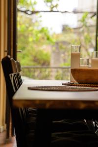 une table avec un bol et une fenêtre dans l'établissement Les Lauriers Roses - Maison d'Hôtes, à Barjac