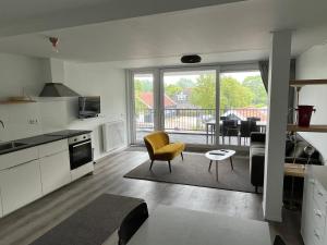 a kitchen and living room with a view of a balcony at Residence het Centrum in Oostkapelle