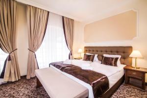 WINDSOR SPA Hotel في كارلوفي فاري: غرفة نوم بسرير كبير ونافذة