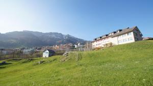 Une colline verdoyante avec un bâtiment en haut dans l'établissement Schwendihaus, à Amden