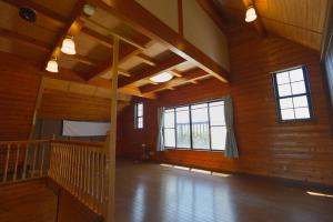 an empty room with wooden walls and windows at ocean resort mint オーシャンビューを満喫!かわいい三角屋根の三階建て貸切別荘 in Shioura