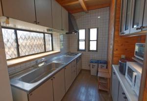 a kitchen with a sink and a stove at ocean resort mint オーシャンビューを満喫!かわいい三角屋根の三階建て貸切別荘 in Shioura