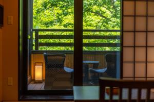 a window view of a table and chairs on a balcony at Suiun in Hakone