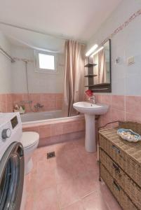 a bathroom with a toilet sink and a washing machine at EMA Red house in Potámion