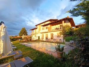 a villa with a swimming pool in front of a house at Domus Langhe B&B in Treiso