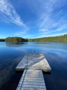 a wooden dock in the middle of a lake at Mökki järven rannalla mäntymetsässä in Forssa