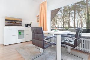 una sala da pranzo con tavolo e 2 sedie di Haus Eva Mar am Meer Appartement 4 a Timmendorfer Strand