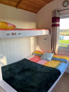 a small room with two bunk beds and a window at Pearl Shepherds Hut in Penally