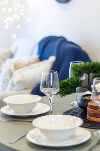 a table with plates and wine glasses on it at Stroll through the park 2 bed 2 bath w/carpark in Christchurch