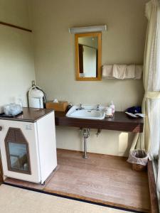 uma casa de banho com um lavatório e um espelho em Ryokan Fujitomita em Oshino