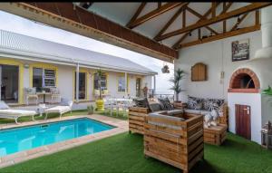 a house with a swimming pool in the yard at Gordon's Beach Lodge in Gordonʼs Bay