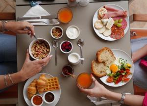 a group of people sitting at a table with breakfast foods at The Maltese Sun in Sliema