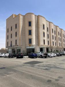 a large building with cars parked in a parking lot at فندق سكناي الياسمين in Hail