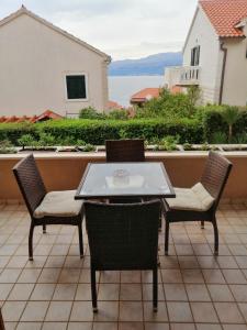 een patio met een tafel en stoelen op een balkon bij Apartment Ema in Postira in Postira