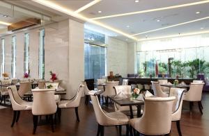 a restaurant with white chairs and tables and a bar at Yuh Tong Hotel in Chiayi City