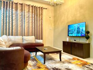 a living room with a couch and a flat screen tv at Homestay D Razak Wakaf Tapai in Marang