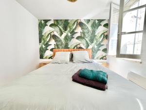 1 dormitorio con 1 cama blanca grande y una pared verde frondoso en Niort - Hyper-Centre - Appartements en Duplex ou Triplex - Wifi Fibre - NOUVEAU, en Niort