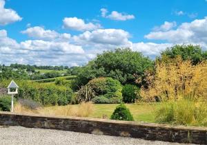 uma vista para um jardim com árvores e arbustos em Little Garden Cottage, Tamar Valley, Cornwall em Stoke Climsland