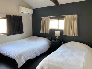 1 Schlafzimmer mit 2 Betten und 2 Fenstern in der Unterkunft Samurai Suite 1 , 15mins from Kyoto Eki , 5 mins to Arashiyama in Kyoto