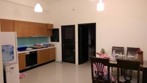 a kitchen with a table and a black refrigerator at B-wei B&B in Hualien City