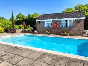 a swimming pool in front of a house at The Pool House in Crediton
