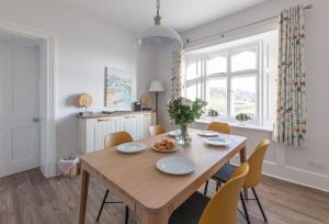 a dining room with a wooden table and chairs at Gurnard Cottage in Niton