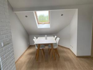 een tafel en stoelen in een kamer met een raam bij Apartament u Uli in Kołobrzeg