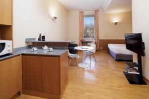 Dynasty Suites Downtown Apartments في تورينو: غرفه فندقيه مع مطبخ وسرير